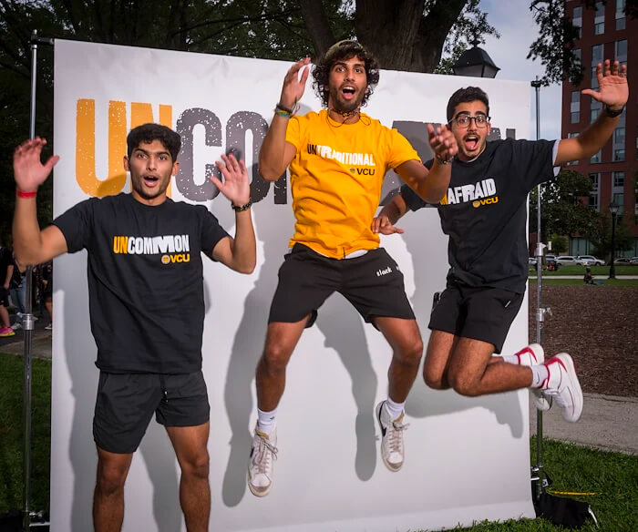 Three VCU students jumping in the air