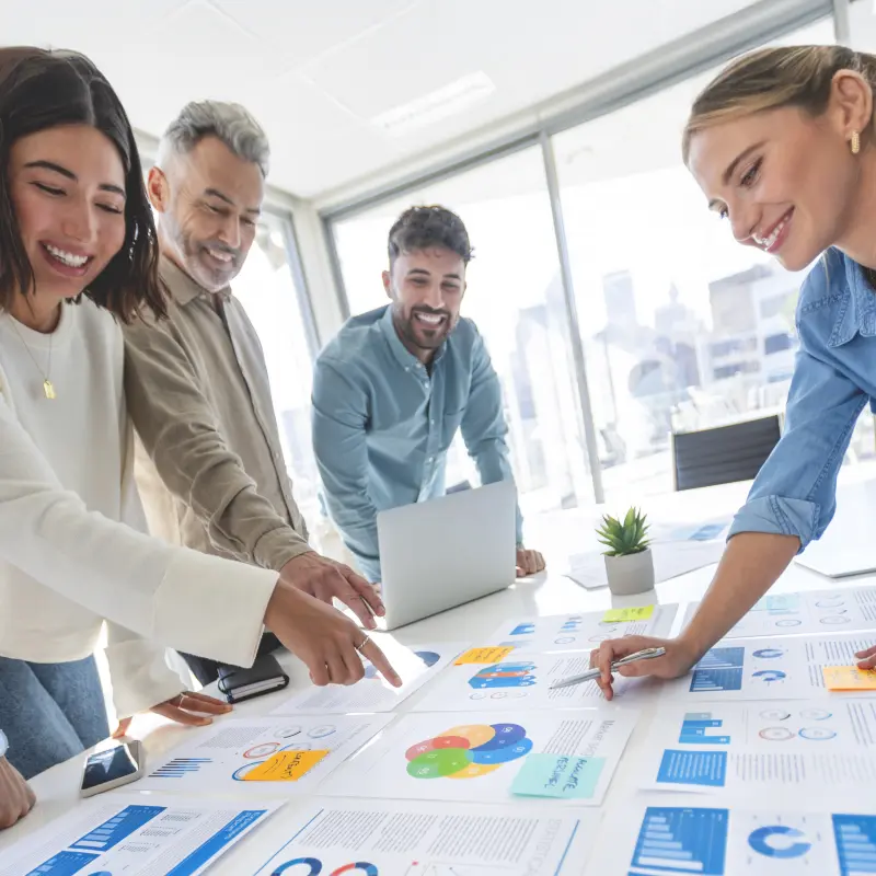 Working professionals collaborating on marketing analytics charts and data strategy, representing career-focused learning in VCU’s online business and marketing programs.
